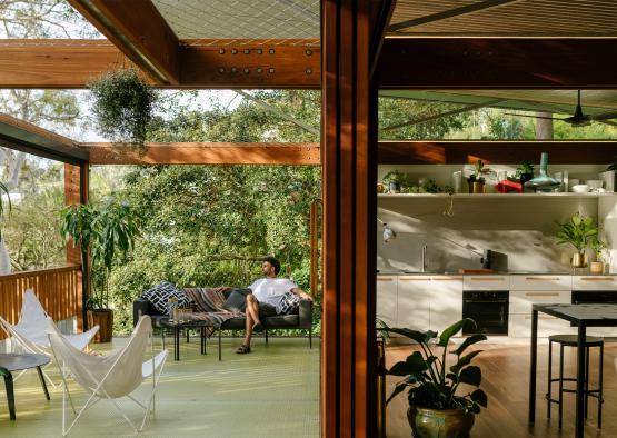 a man sitting on a couch in a covered patio
